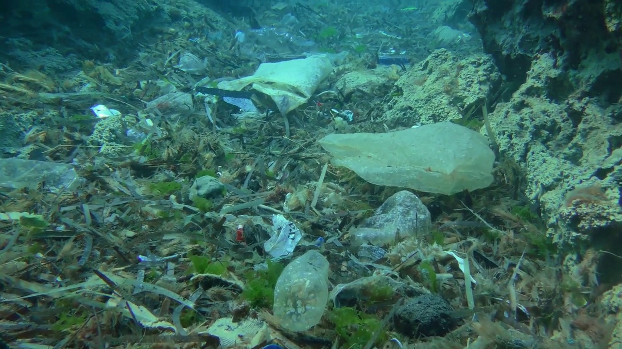 塑料污染的海洋:食品包装在海底附近的海滩地区，地中海。视频素材