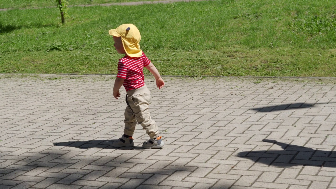 孩子们在户外操场上玩耍，孩子们在阳光明媚的幼儿园院子里玩耍。活泼的1.5岁幼儿。儿童健康的夏季活动。视频素材