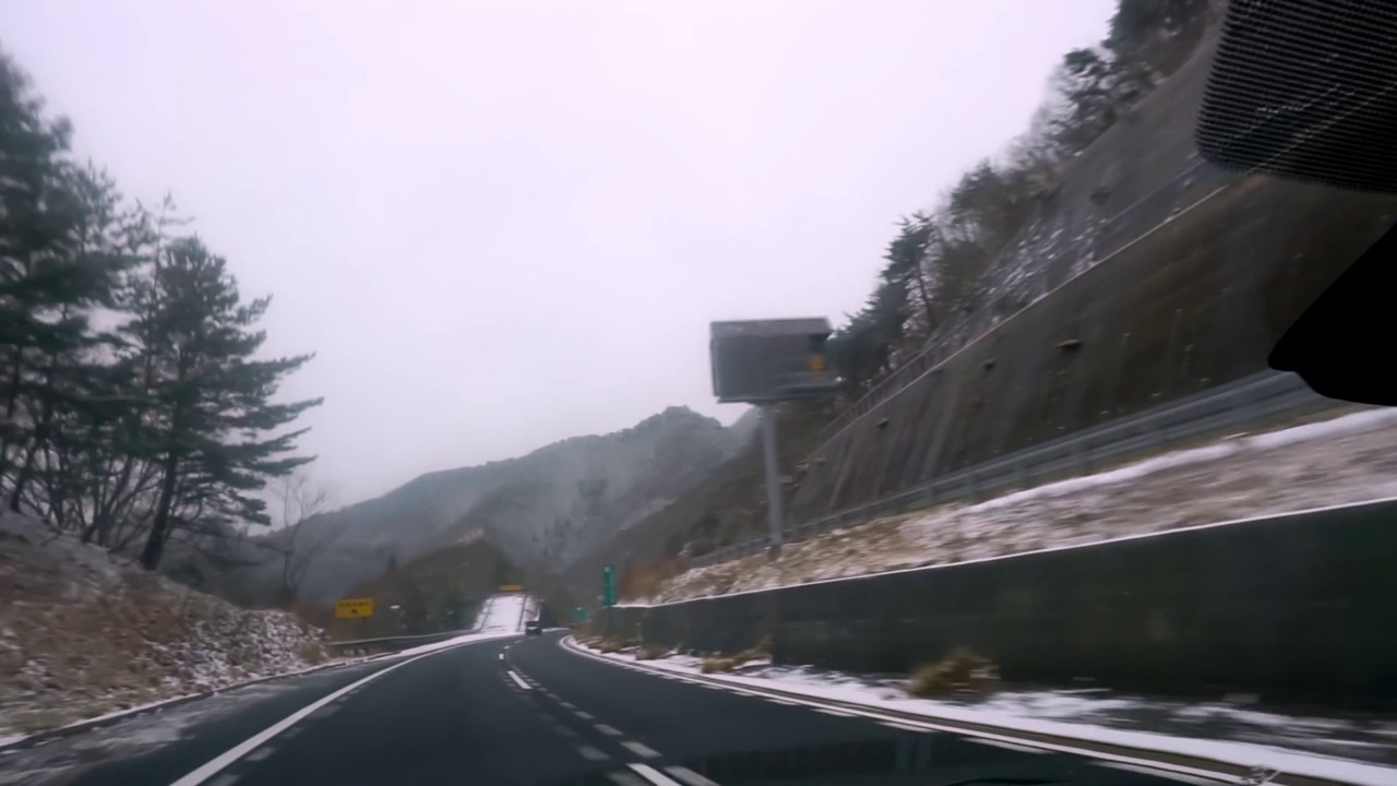 在日本的雪山山脉中行驶的汽车内的景色。视频素材