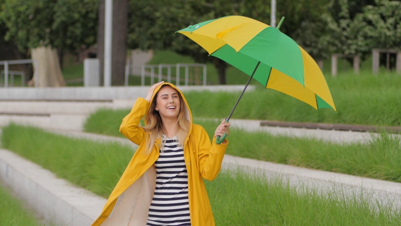 积极的情绪年轻可爱的女人伞下升开始下雨享受在一个城市散步视频素材