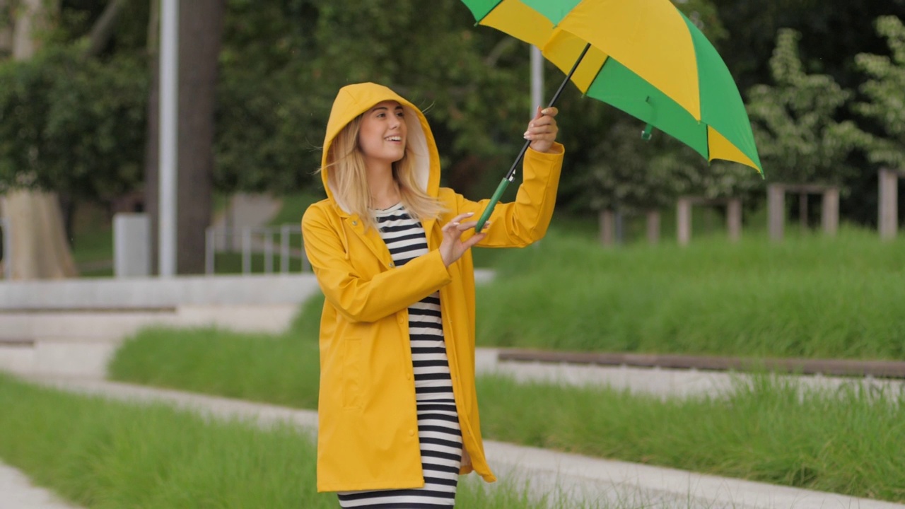 积极的情绪年轻可爱的女人伞下升开始下雨享受在一个城市散步视频素材