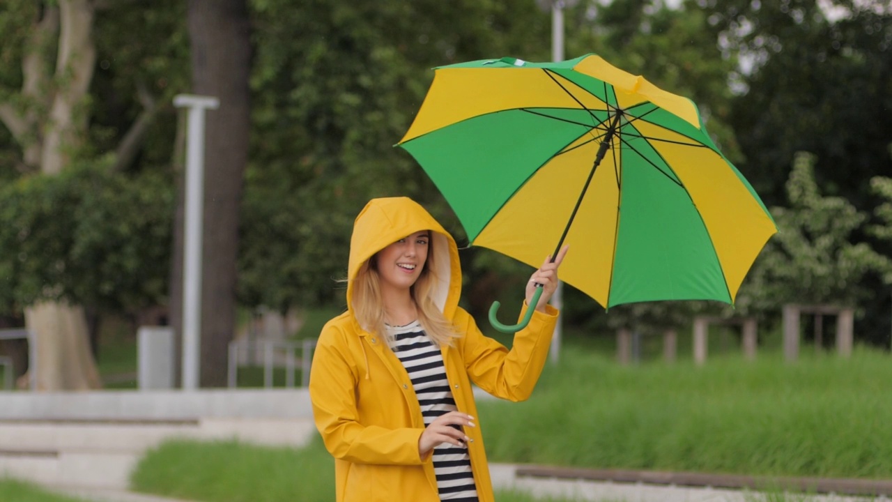 积极的情绪年轻可爱的女人伞下升开始下雨享受在一个城市散步视频素材