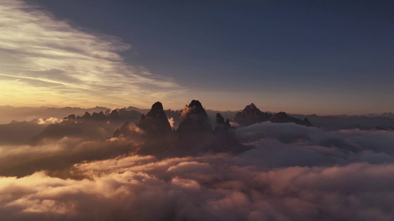 夏日日落时，一架无人机拍摄了意大利白云石，拉瓦雷多Tre Cime di Lavaredo周围的云层视频素材