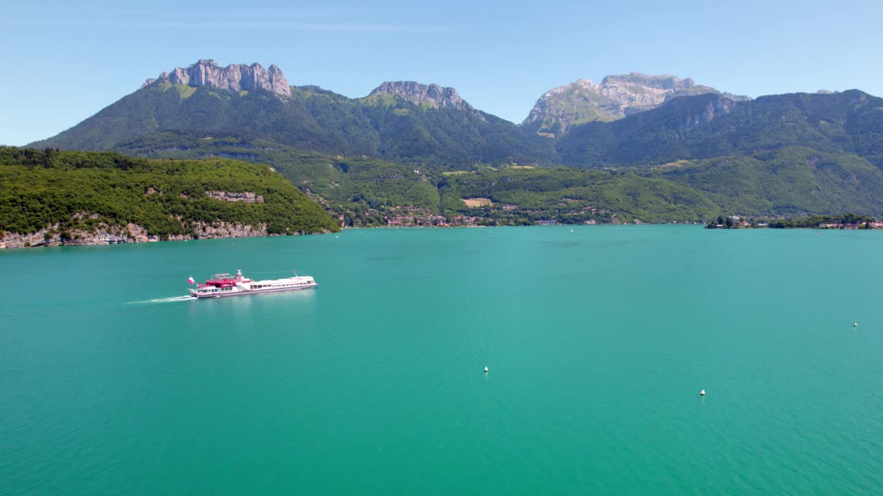 鸟瞰安纳西湖、山脉、森林和穿越上萨瓦旅游热点的游轮视频素材