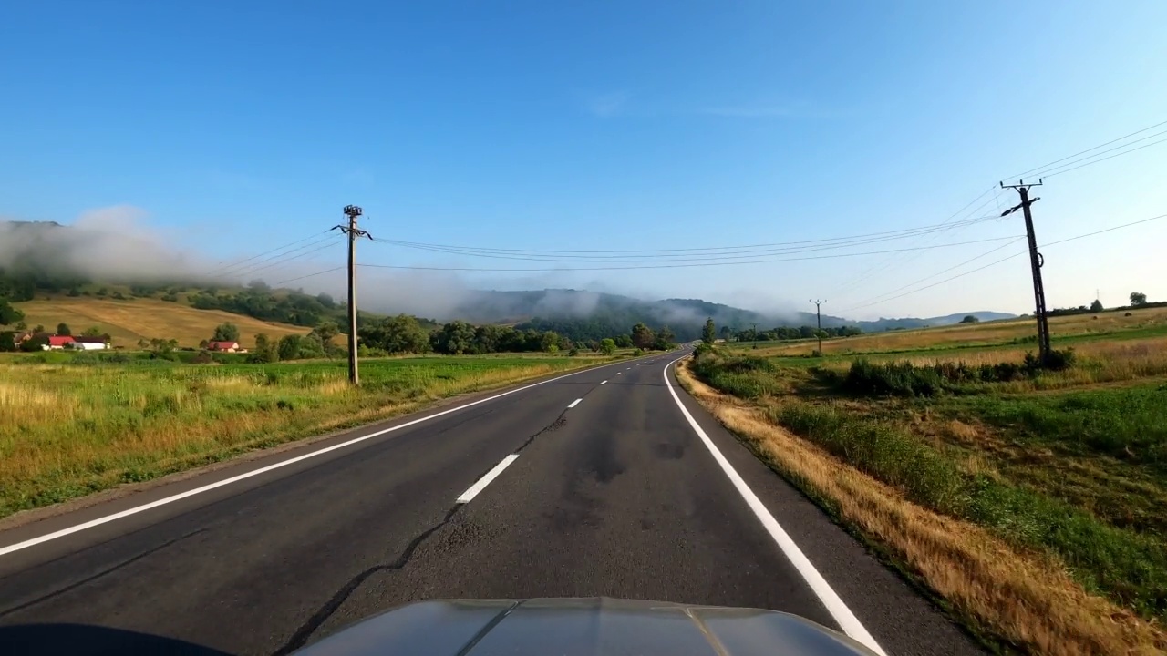 POV拍摄的一辆汽车沿着森林和山脉的道路行驶。夏天开车旅行视频素材