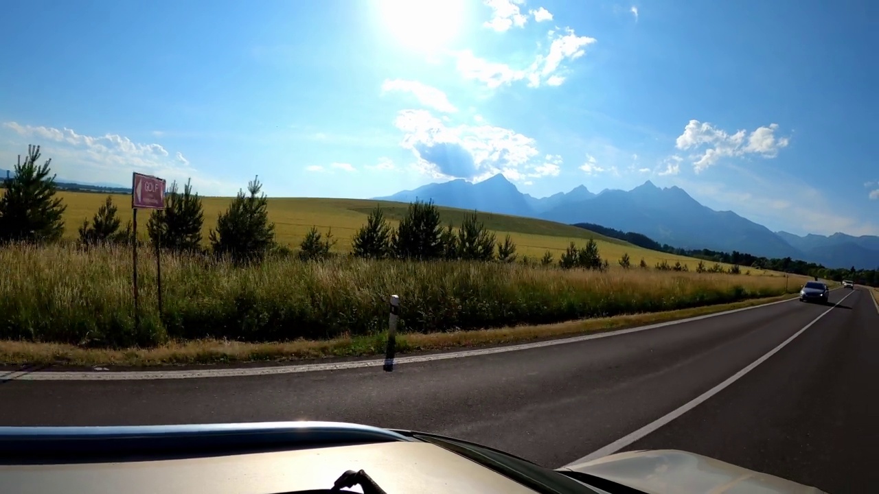 POV拍摄的一辆汽车沿着森林和山脉的道路行驶。夏天开车旅行视频素材