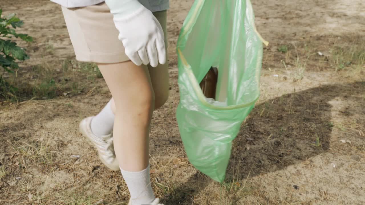 一名志愿者在森林里收集塑料垃圾。视频素材