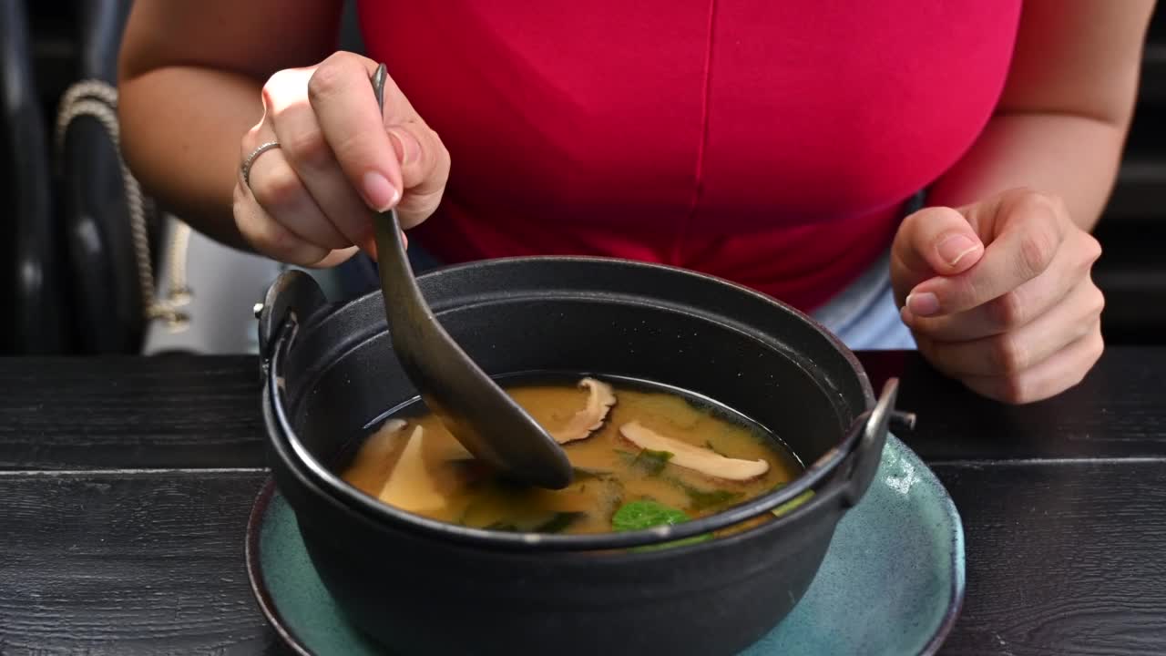 在餐厅吃日本味噌汤配豆腐芝士的女人视频素材