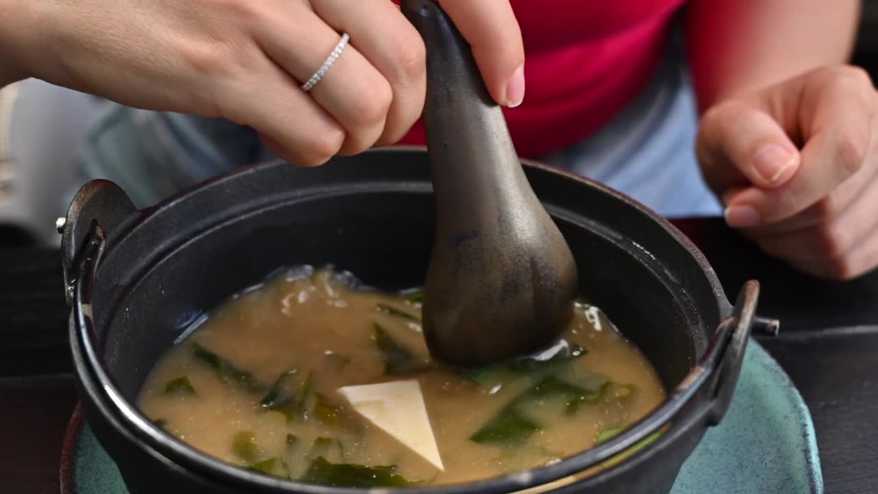 在餐厅吃日本味噌汤配豆腐芝士的女人视频素材