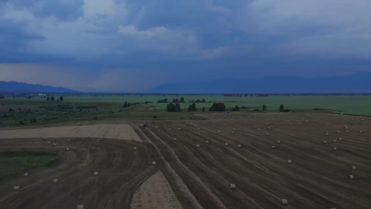 雷雨天气下，阿尔泰农场工人在农田上劳作视频素材