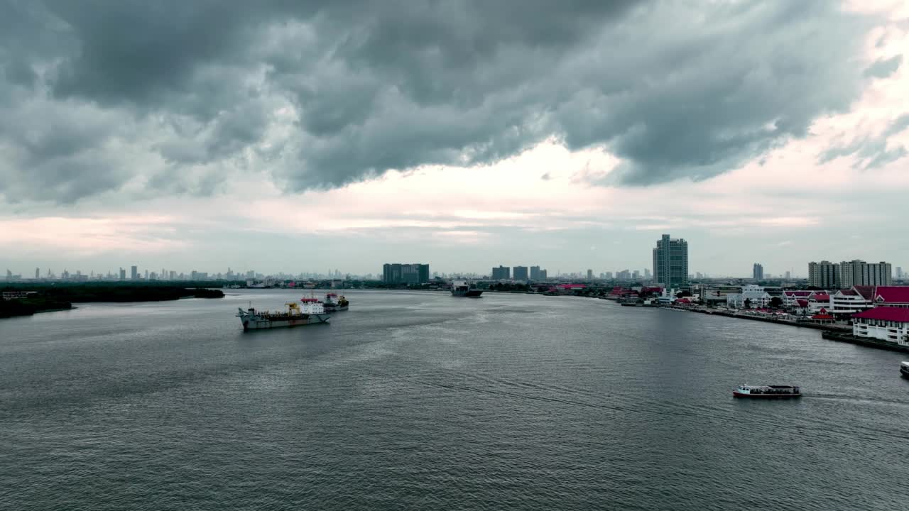 鸟瞰图，大型货船载着少量集装箱在江中行驶，城市景色和美丽的云朵。对于进出口业务，物流业务，由于战争而萧条。视频素材