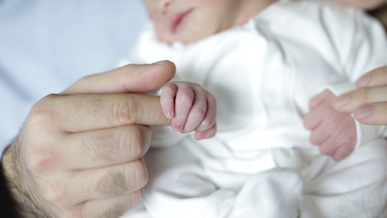新生婴儿握住父母的手指视频素材