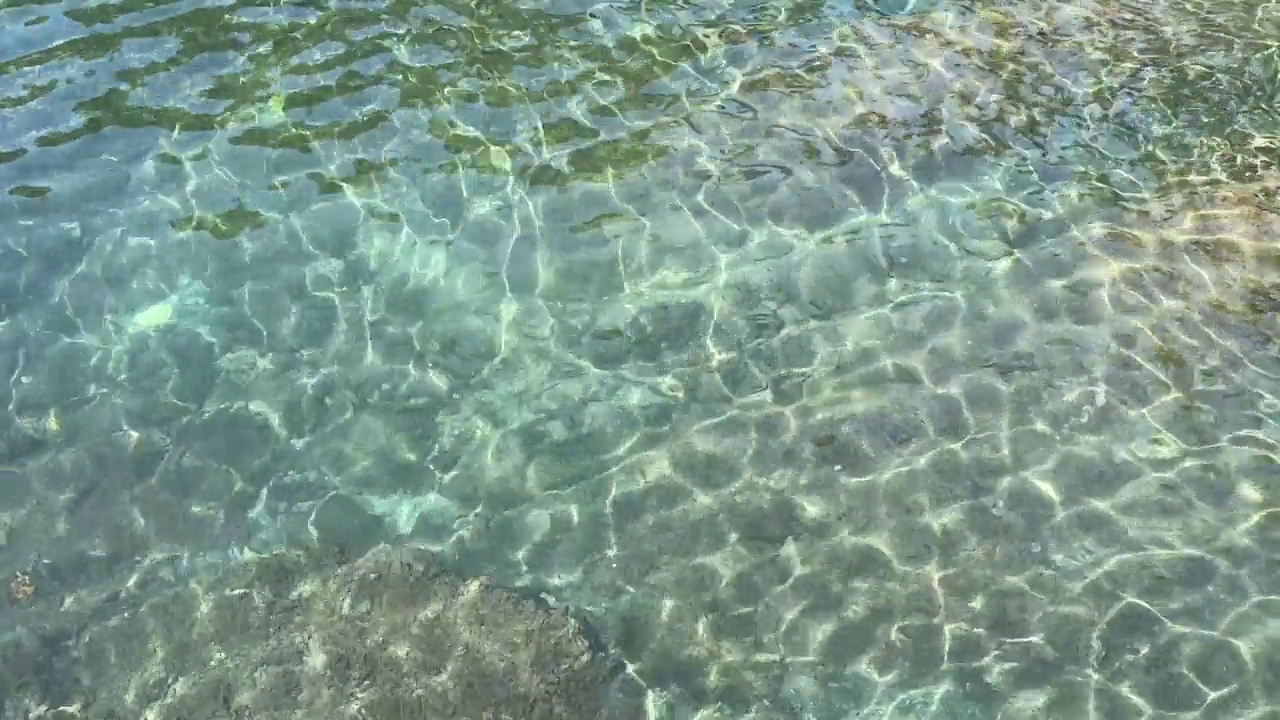 美丽的蓝绿色海水。水面波浪在阳光下闪闪发光。夕阳照射在波浪上的耀眼光芒。视频素材