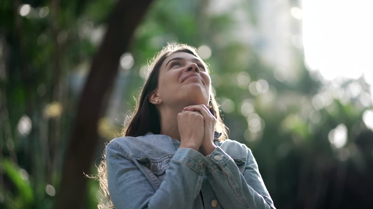 幸福的女人心存感激。灵性女孩祈祷，望着充满希望的天空视频素材