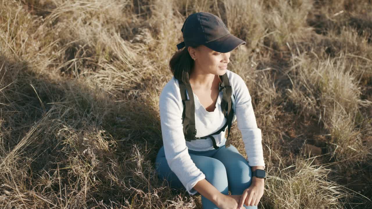 一个快乐的年轻女子躺在草地上，探索和远足户外的自然小径。喜欢冒险的徒步旅行者，在宁静和孤独中放松，感受自由和平静视频素材