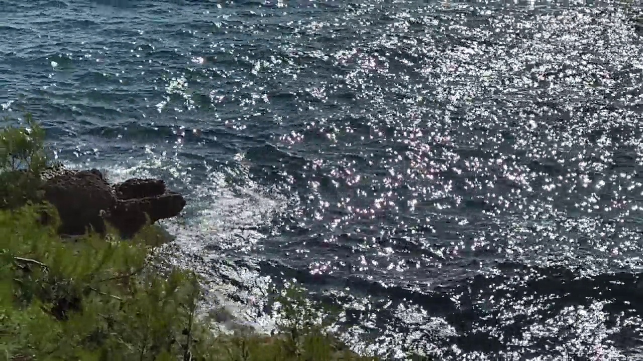 海滩上湛蓝的海浪闪闪发光。美丽的闪闪发光的海景。视频素材