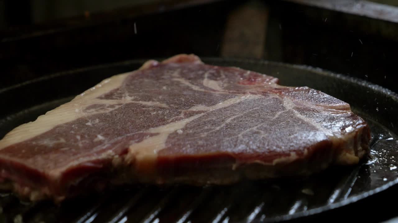 丁字牛排在烤盘里烤肉。视频素材