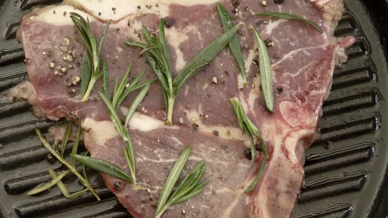 丁字牛排在烤盘里烤肉。视频素材