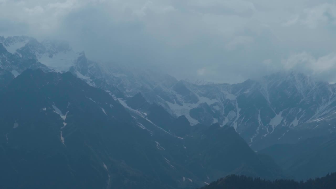 在印度喜马偕尔邦的马纳利，季风期间，积雪覆盖的喜马拉雅山脉景观与暴风雨般的乌云在山顶。季风在山脉。暴风雪笼罩着雪山。视频素材