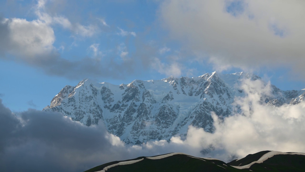 山间美丽的延时摄影。雪覆盖的山和云的时间流逝。视频素材