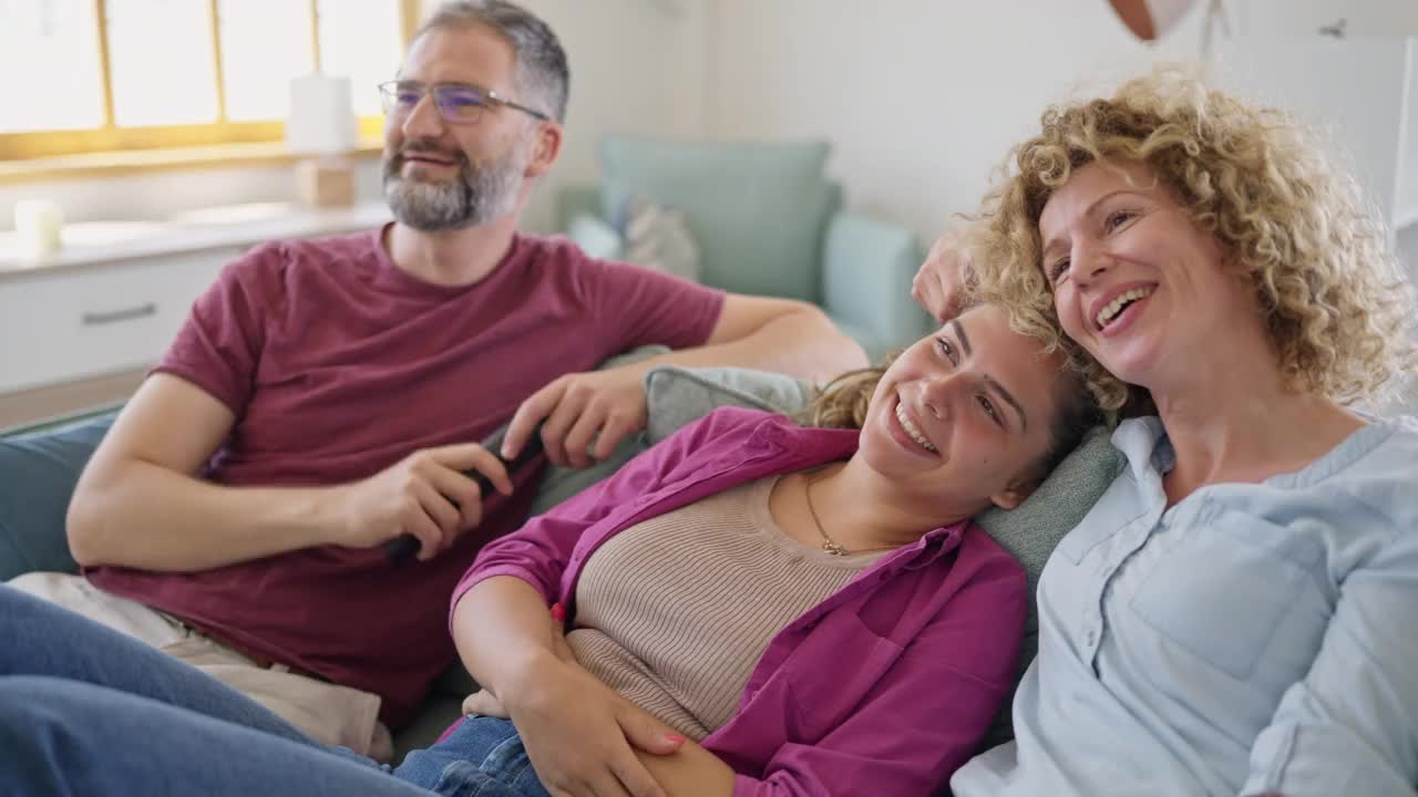 白种人家庭在客厅看电视的时候玩得很开心视频素材