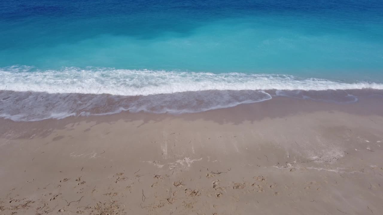 鸟瞰美丽的沙滩和柔和的蓝绿色海浪。莱夫卡达岛Megali Petra海滩夏季的热带海洋。视频素材