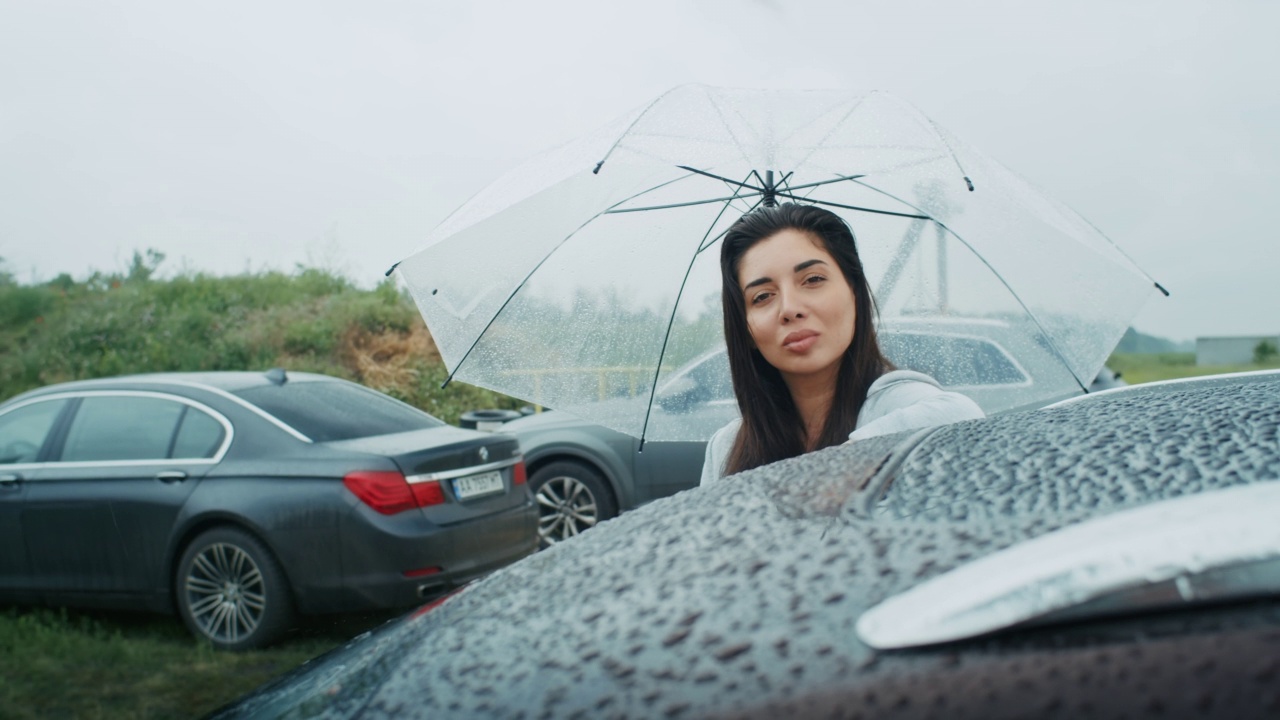 一个悲伤的亚美尼亚女人撑着伞在雨中行走。她喜欢这种天气。视频素材