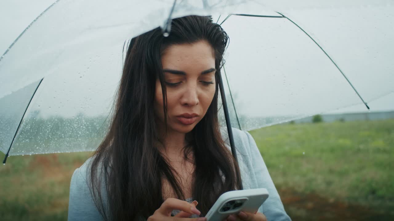 一个悲伤的亚美尼亚女人在雨中打电话，视频素材