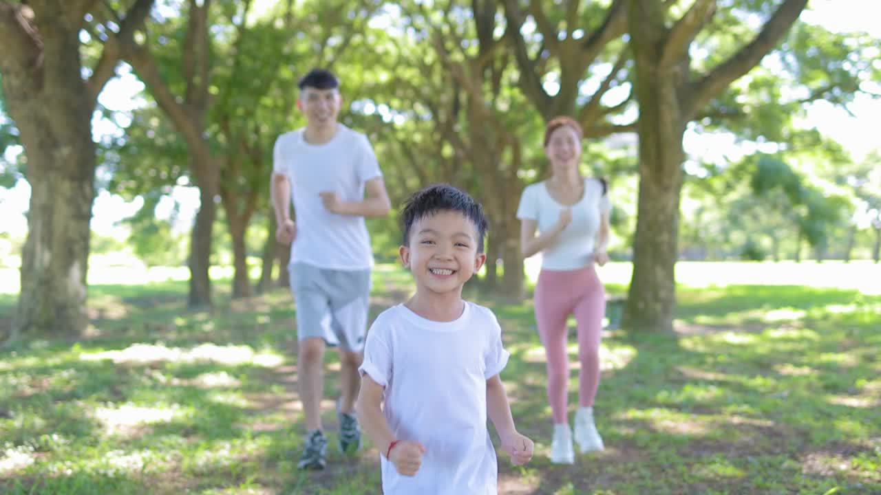 快乐的男孩和父母在城市公园慢跑视频素材