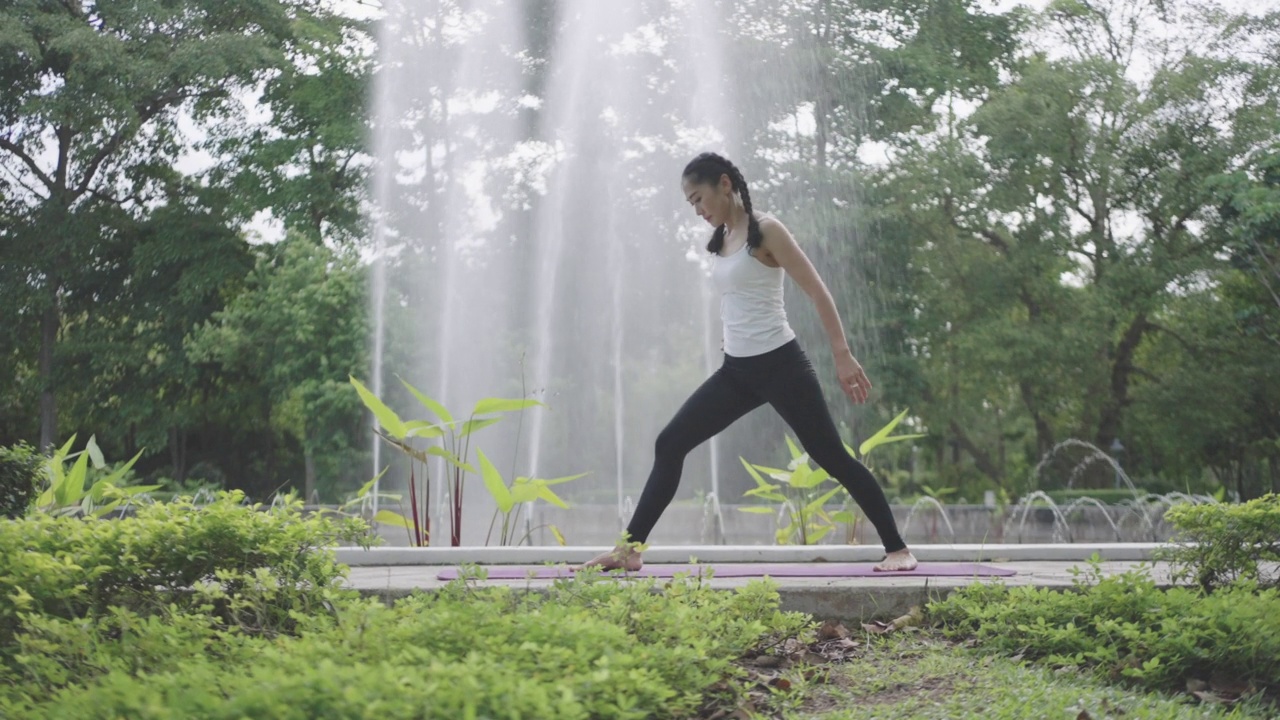 亚洲妇女在公园里做瑜伽。视频素材