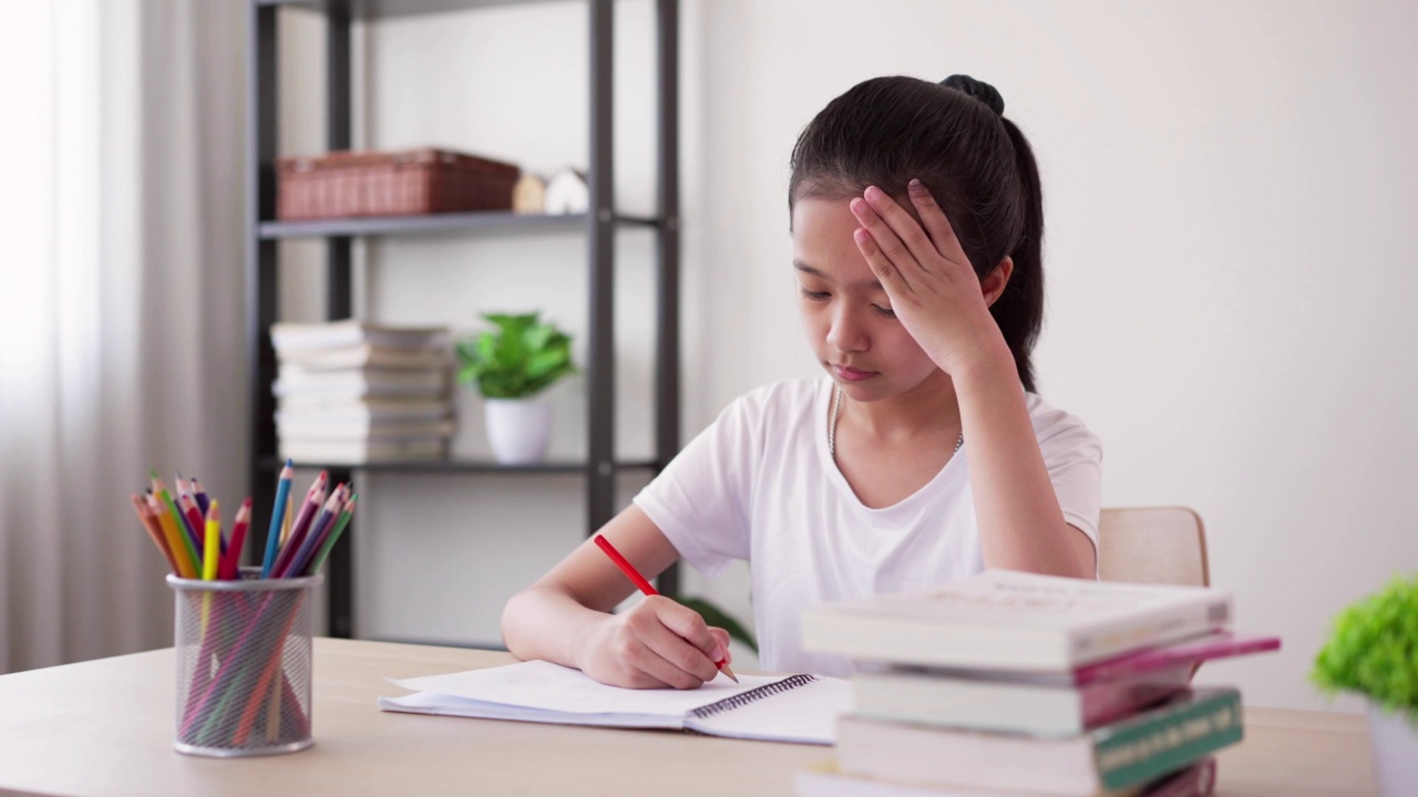 压力集中的女孩在家里学习和做作业感到头痛视频素材