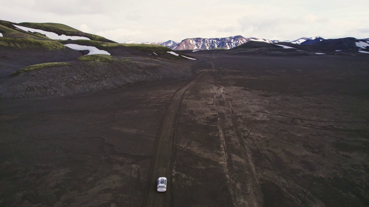 公路旅行4 × 4汽车驾驶在砾石路之间的熔岩田附近的火山口在冰岛夏季的冰岛高地视频素材