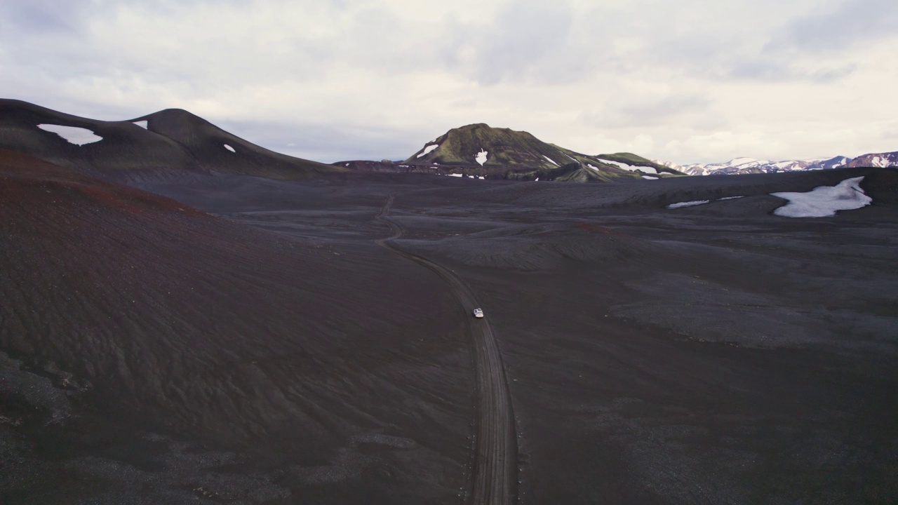 公路旅行4 × 4汽车驾驶在砾石路之间的熔岩田附近的火山口在冰岛夏季的冰岛高地视频素材