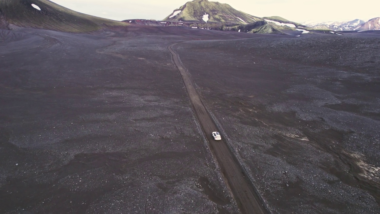 公路旅行4 × 4汽车驾驶在砾石路之间的熔岩田附近的火山口在冰岛夏季的冰岛高地视频素材