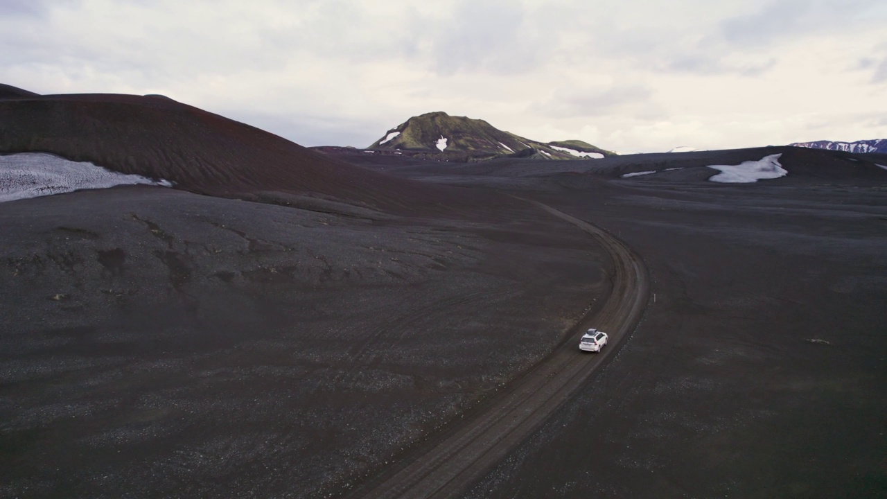 公路旅行4 × 4汽车驾驶在砾石路之间的熔岩田附近的火山口在冰岛夏季的冰岛高地视频素材