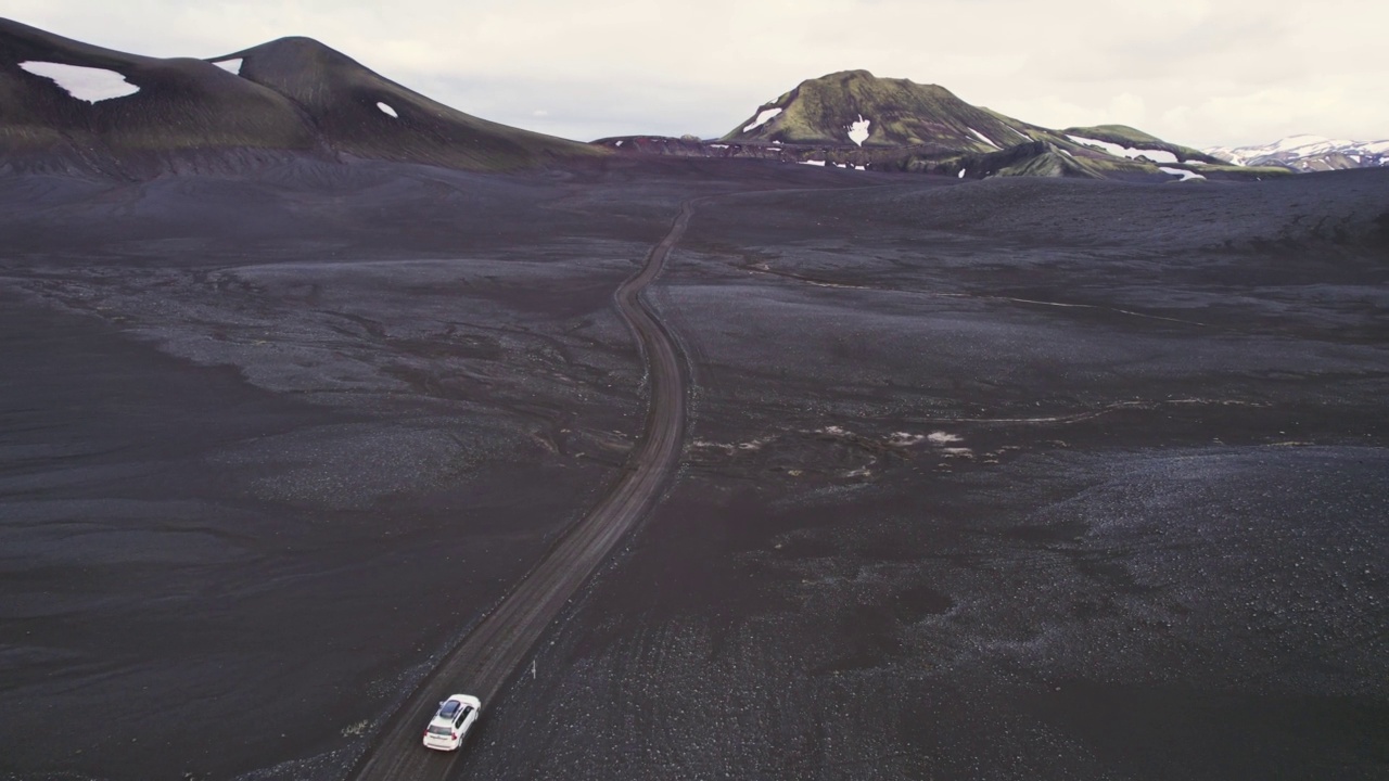 公路旅行4 × 4汽车驾驶在砾石路之间的熔岩田附近的火山口在冰岛夏季的冰岛高地视频素材