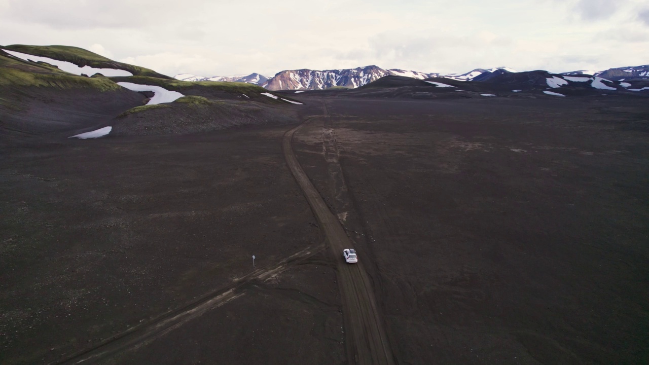 公路旅行4 × 4汽车驾驶在砾石路之间的熔岩田附近的火山口在冰岛夏季的冰岛高地视频素材