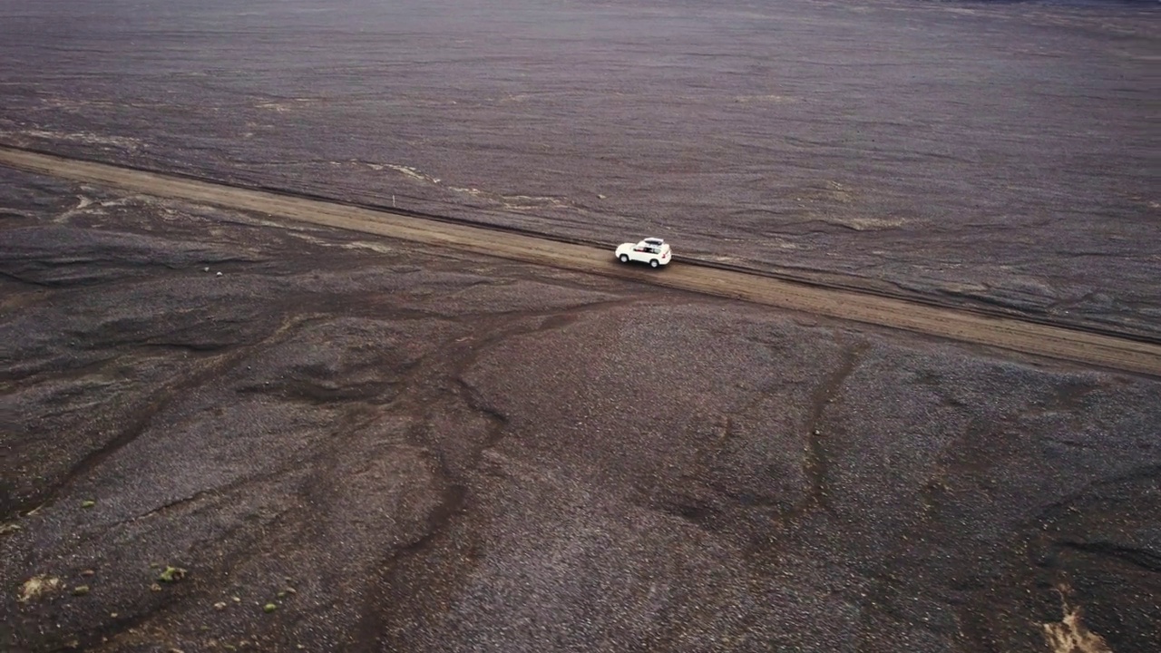 公路旅行4 × 4汽车驾驶在砾石路之间的熔岩田附近的火山口在冰岛夏季的冰岛高地视频素材