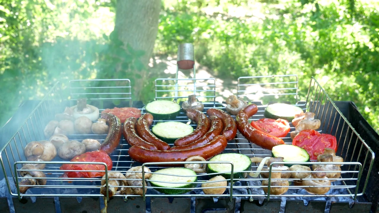 油炸香肠、蔬菜和蘑菇用烹饪刷涂抹。烤香肠在户外烧烤。B-B-Q。概念食物野餐和野营。特写镜头视频素材