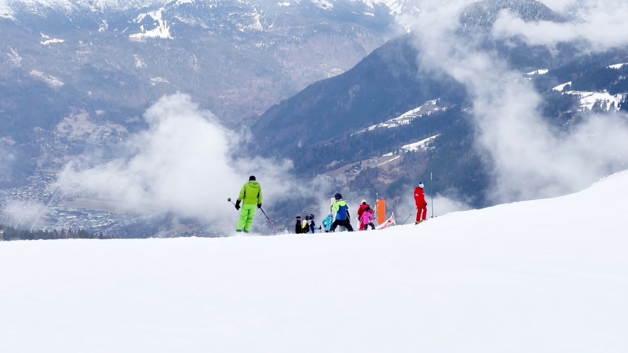 在高山滑雪胜地，许多滑雪者从斜坡上滑下来视频素材