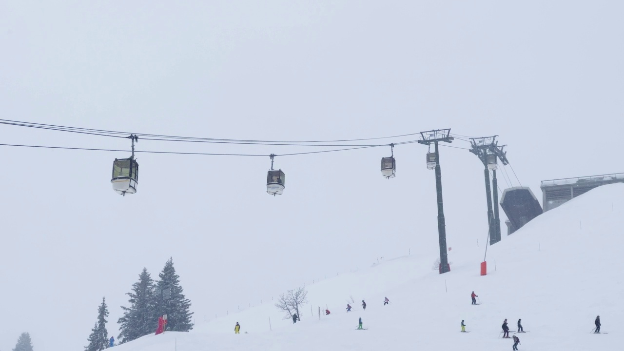 下雪时在高山滑雪场的索道上的滑雪缆车视频素材