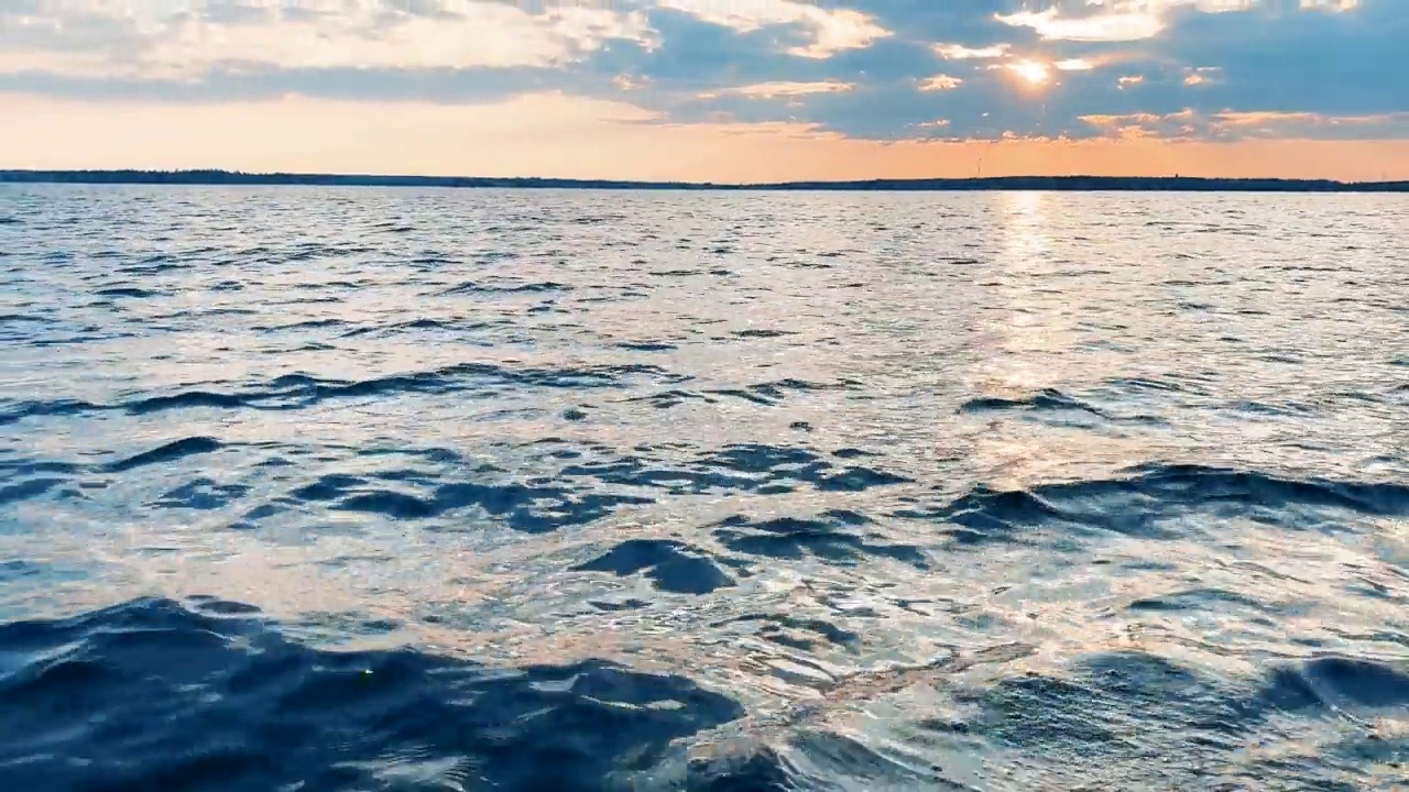 水表面。日落的天空背景。湖上金色的夕阳。清水纹理。景观。运动中有反射的水视频素材