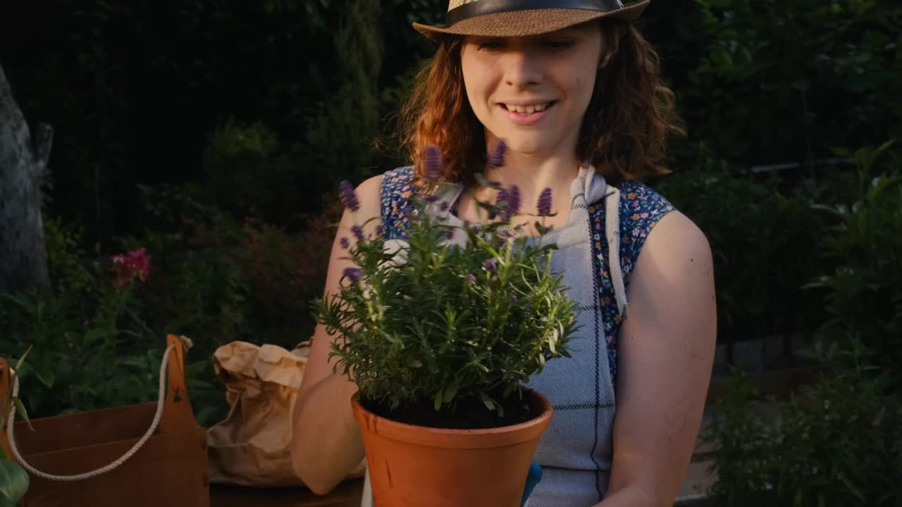 年轻女子在户外照顾盆栽植物。视频素材