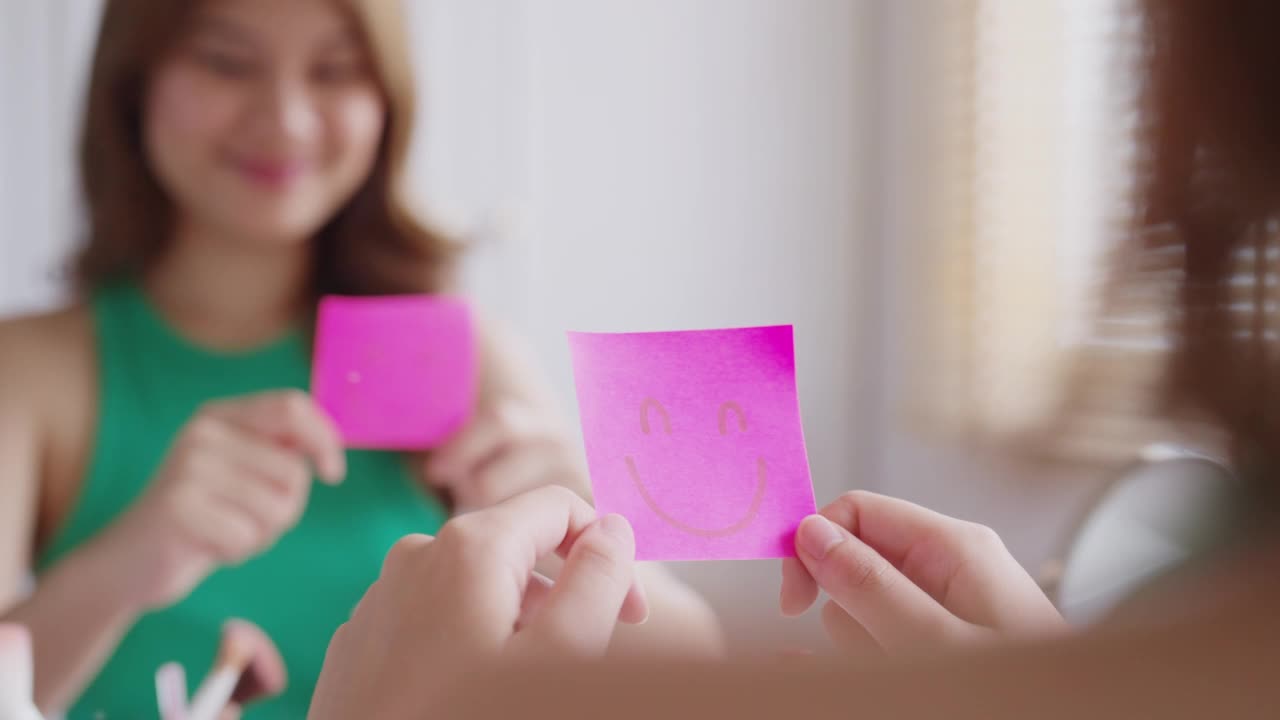 亚洲女性在镜子前用微笑便利贴自言自语。视频素材