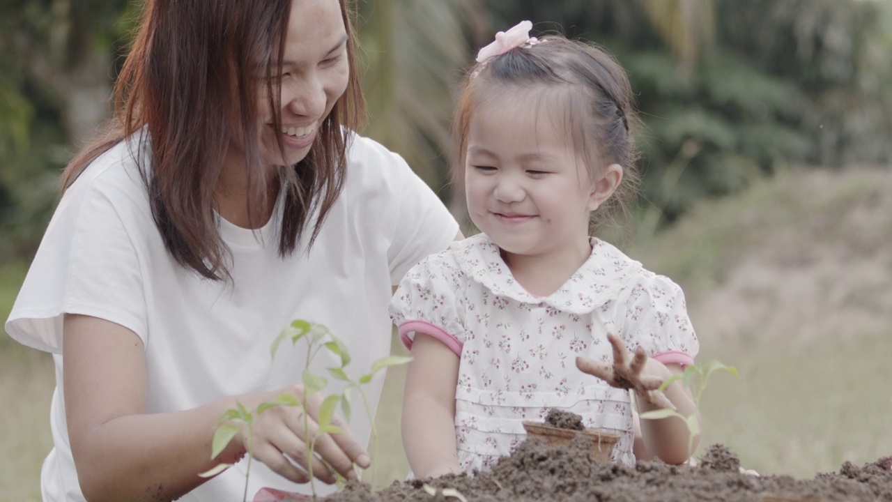 亚洲小女孩和父母一起种植幼苗视频素材