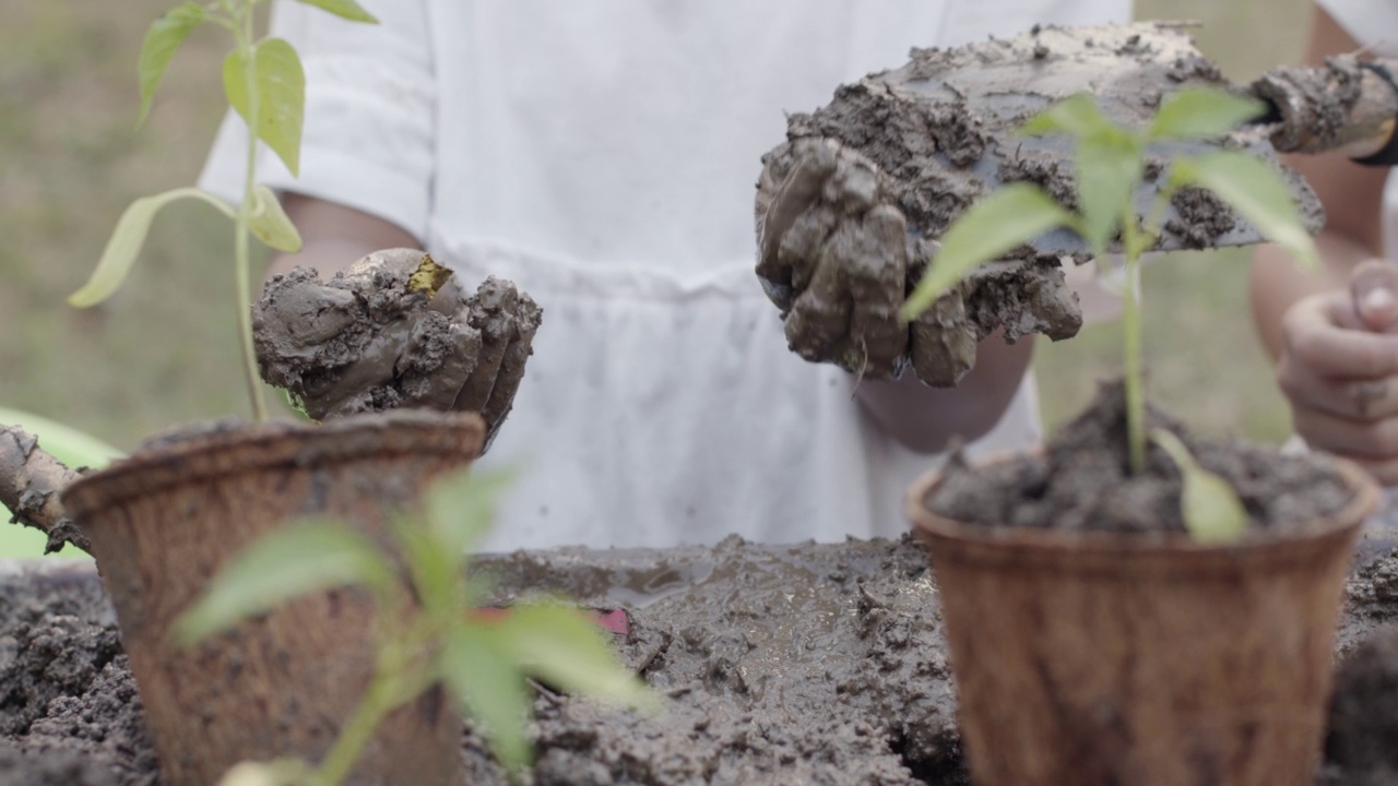 近距离观察孩子在种植后用脏手玩泥巴视频素材