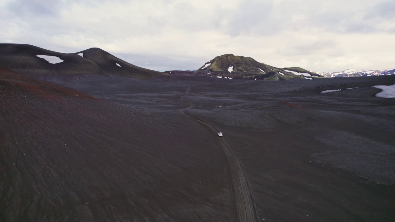 公路旅行4 × 4汽车驾驶在砾石路之间的熔岩田附近的火山口在冰岛夏季的冰岛高地视频素材