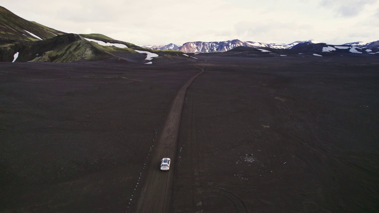 公路旅行4 × 4汽车驾驶在砾石路之间的熔岩田附近的火山口在冰岛夏季的冰岛高地视频素材