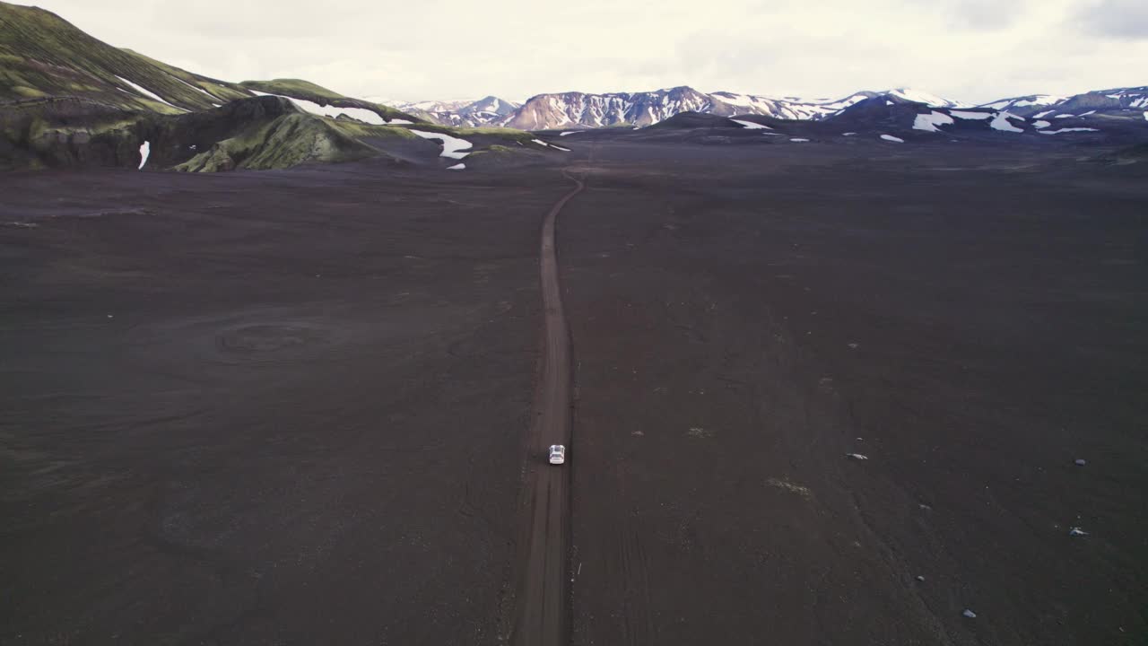 公路旅行4 × 4汽车驾驶在砾石路之间的熔岩田附近的火山口在冰岛夏季的冰岛高地视频素材