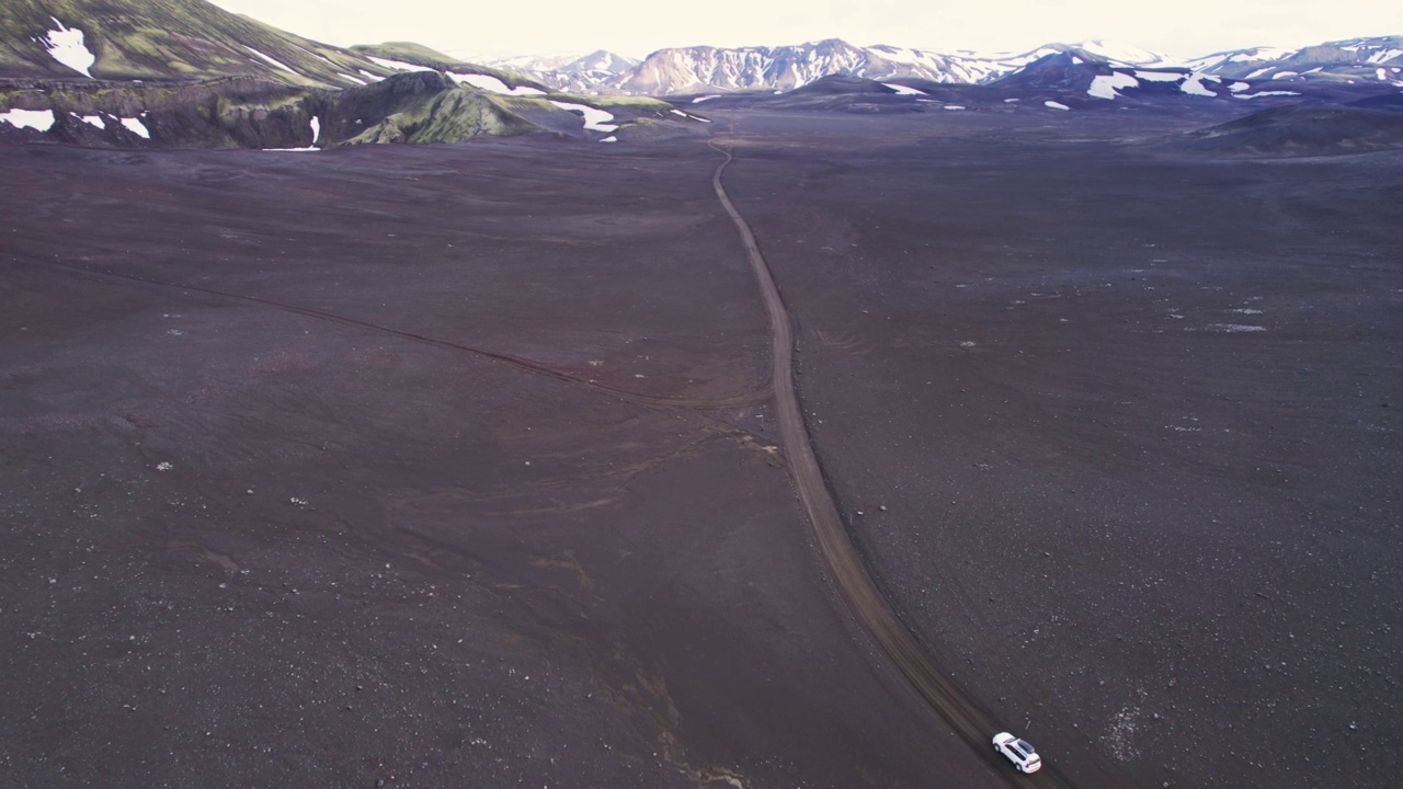 公路旅行4 × 4汽车驾驶在砾石路之间的熔岩田附近的火山口在冰岛夏季的冰岛高地视频素材